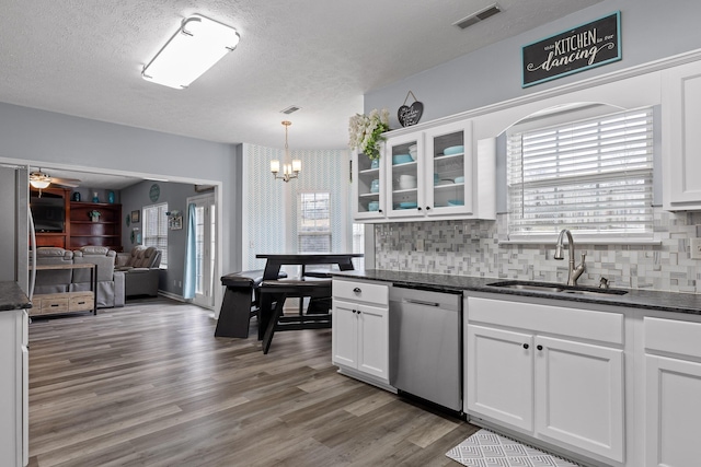 kitchen featuring sink, hardwood / wood-style flooring, dishwasher, white cabinets, and decorative light fixtures