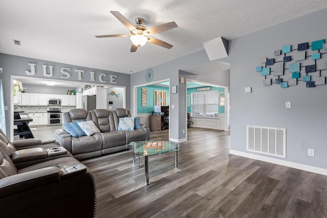 living room featuring hardwood / wood-style floors, a textured ceiling, and ceiling fan