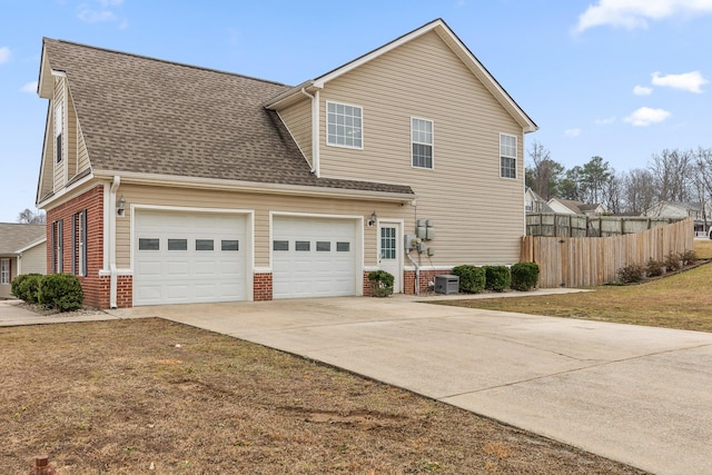 view of front facade featuring a garage, central AC unit, and a front yard