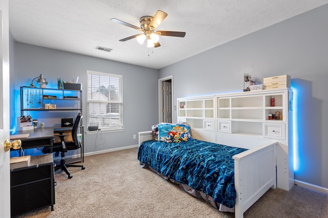 carpeted bedroom with ceiling fan and a textured ceiling