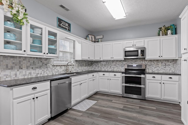 kitchen featuring stainless steel appliances, sink, white cabinets, and dark hardwood / wood-style floors