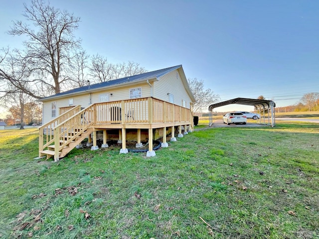 rear view of house featuring a carport, a wooden deck, and a lawn