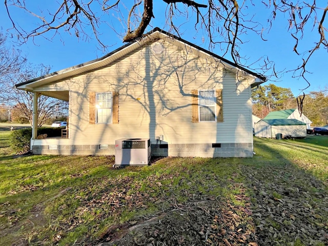 rear view of house featuring a lawn and central air condition unit