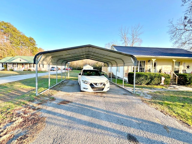 view of parking / parking lot featuring a yard and a carport