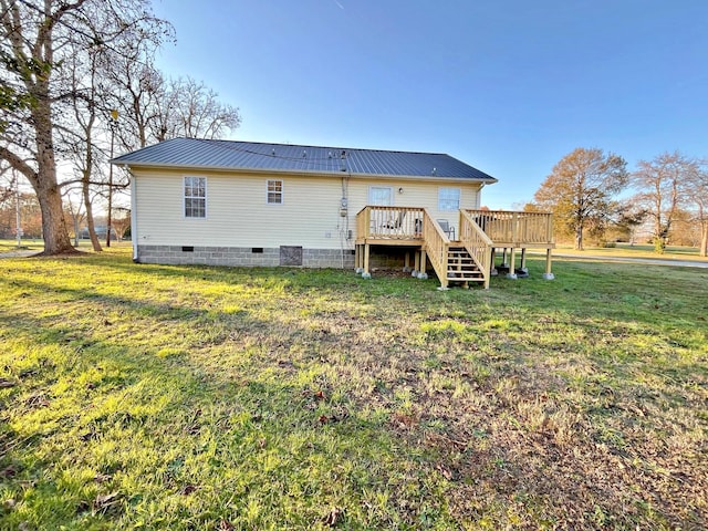 rear view of property featuring a yard and a wooden deck