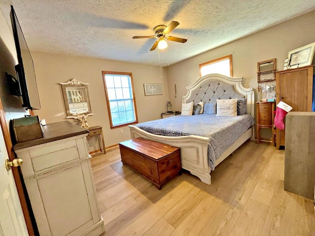 bedroom featuring a textured ceiling, light hardwood / wood-style flooring, and ceiling fan