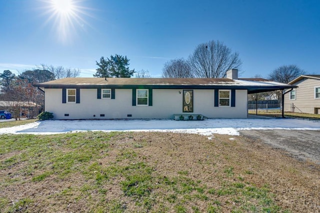 ranch-style house with a carport and a front lawn