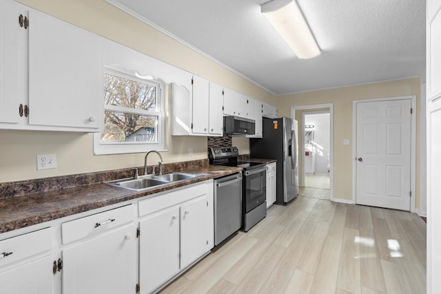 kitchen featuring stainless steel appliances, a textured ceiling, sink, light hardwood / wood-style flooring, and white cabinetry