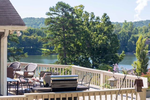 deck with a water view and a grill