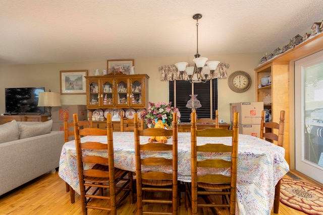 dining room featuring a chandelier, a textured ceiling, and light hardwood / wood-style floors