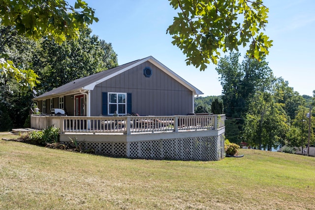 rear view of property featuring a wooden deck and a yard