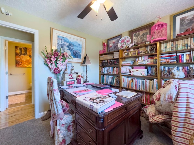 office area featuring carpet flooring, ceiling fan, and a textured ceiling