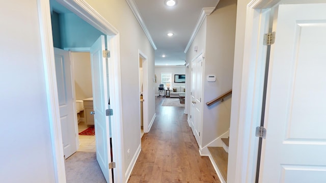 hall with crown molding and light wood-type flooring