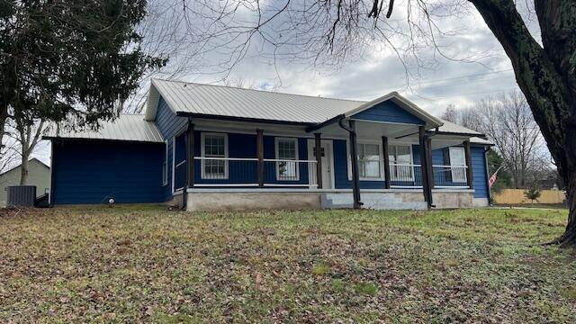 view of front of home featuring central AC, a front lawn, and covered porch