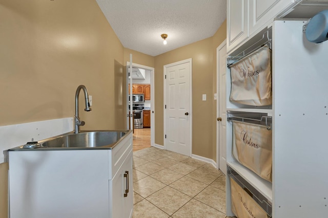 271 Hidden Oaks Trl NE, Cleveland, TN 37312 - kitchen with light tile patterned flooring, appliances with stainless steel finishes, a textured ceiling, and white cabinetry