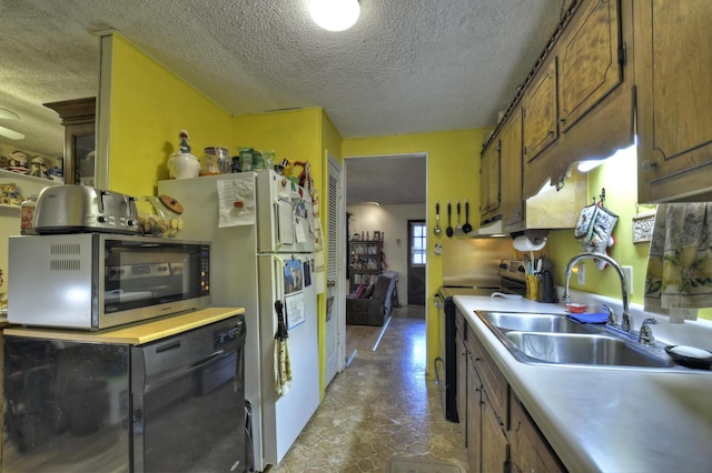 kitchen featuring light countertops, a sink, stainless steel appliances, and brown cabinetry