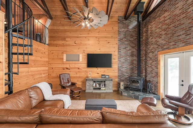 living room with wood walls, wooden ceiling, a wood stove, high vaulted ceiling, and beam ceiling