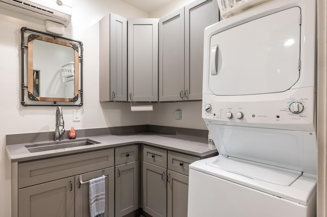 laundry room with cabinets, sink, and stacked washer and dryer