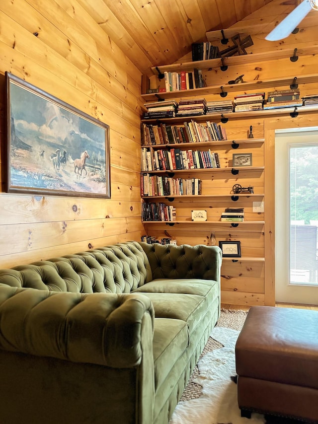 living area with wooden walls, wooden ceiling, and vaulted ceiling