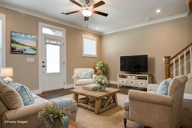 living area with baseboards, ceiling fan, wood finished floors, and crown molding