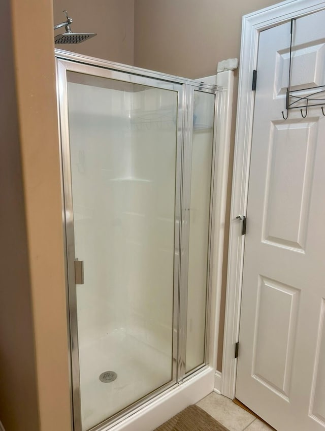 bathroom with an enclosed shower and tile patterned floors