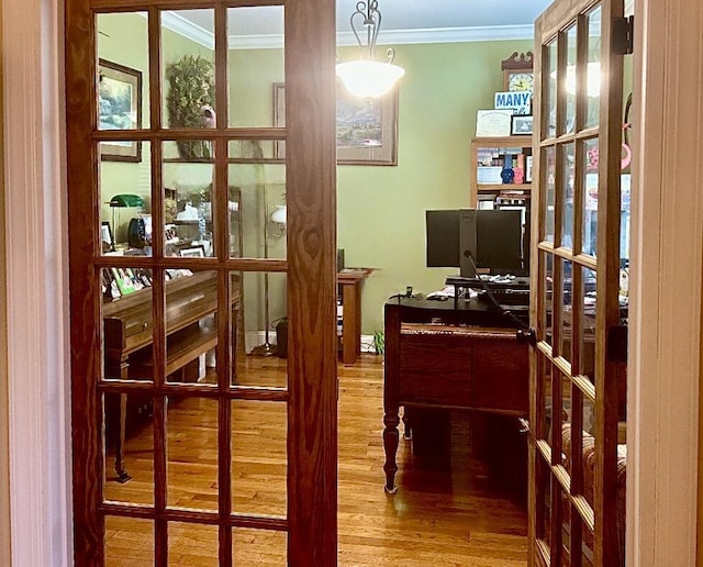 home office featuring french doors, ornamental molding, and hardwood / wood-style floors