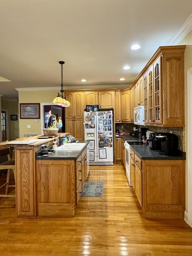 kitchen with tasteful backsplash, decorative light fixtures, light hardwood / wood-style flooring, ornamental molding, and white appliances