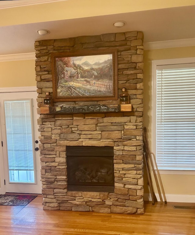 room details featuring hardwood / wood-style flooring, ornamental molding, and a fireplace