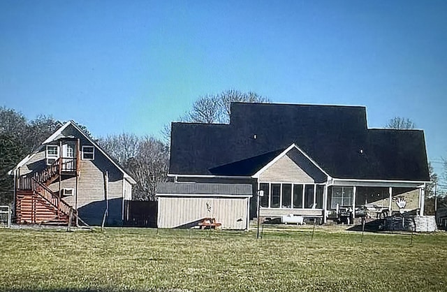 back of property featuring a lawn and a sunroom