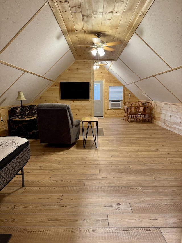 bonus room featuring hardwood / wood-style flooring, ceiling fan, cooling unit, vaulted ceiling, and wood walls