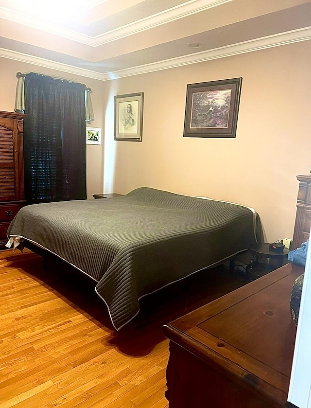 bedroom featuring ornamental molding and light hardwood / wood-style flooring