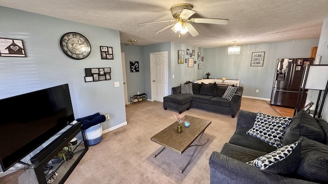 living area with ceiling fan, carpet, baseboards, and a textured ceiling