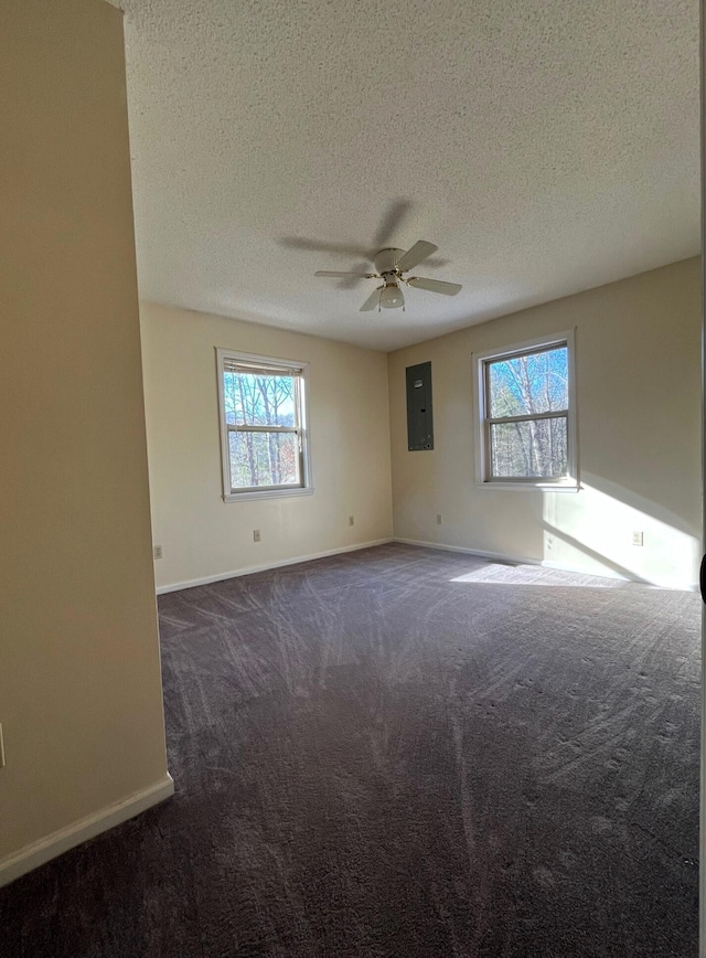 carpeted empty room featuring ceiling fan, electric panel, and a textured ceiling