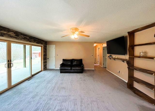 unfurnished room with ceiling fan, a textured ceiling, and carpet