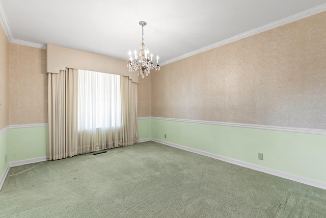 carpeted spare room featuring an inviting chandelier and ornamental molding