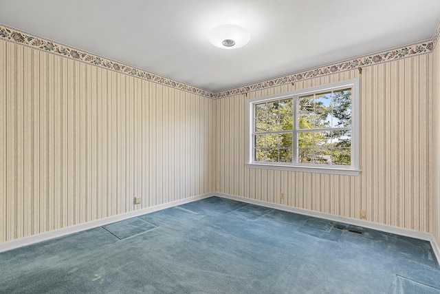 spare room with dark colored carpet