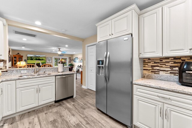 407 Kahite Trl, Vonore, TN 37885 - kitchen with appliances with stainless steel finishes, a sink, light wood-style flooring, a ceiling fan, and tasteful backsplash