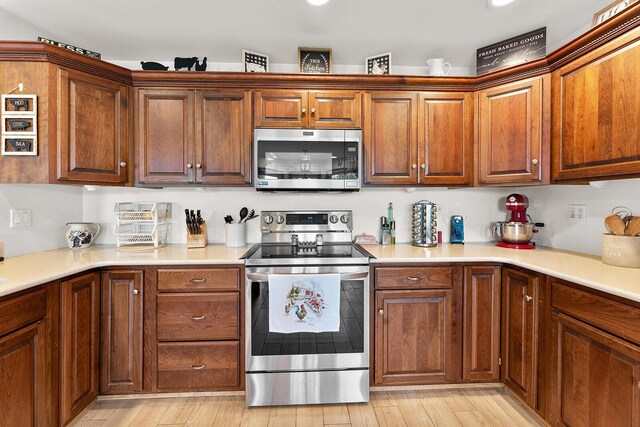 407 Kahite Trl, Vonore, TN 37885 - kitchen with stainless steel appliances, light wood-style flooring, light countertops, and brown cabinets