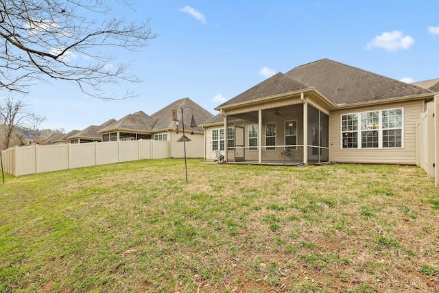 back of property featuring ceiling fan, a sunroom, and a lawn