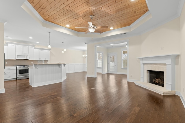 unfurnished living room featuring wood ceiling, ceiling fan, ornamental molding, and a raised ceiling