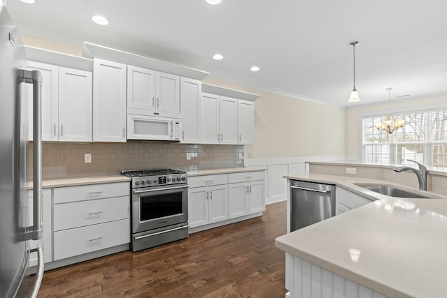 kitchen featuring sink, hanging light fixtures, white cabinets, and appliances with stainless steel finishes