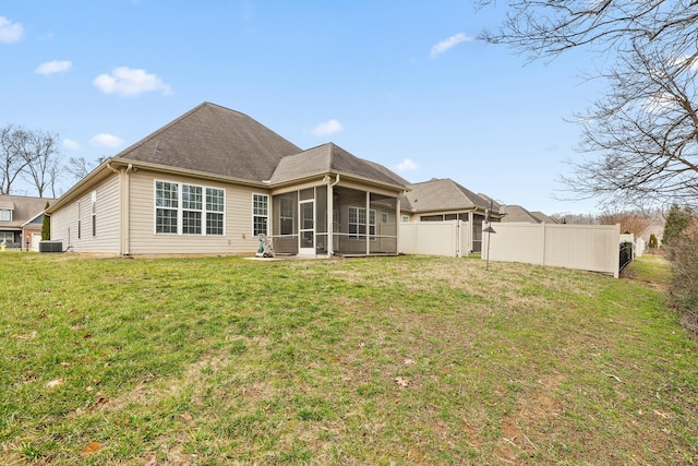 rear view of property featuring a sunroom and a yard