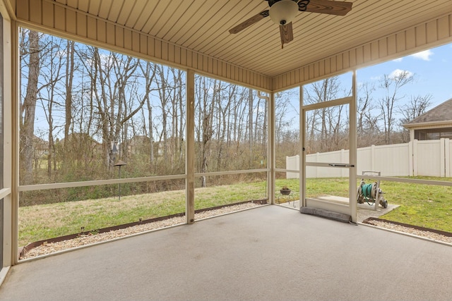 unfurnished sunroom featuring wood ceiling, a wealth of natural light, and ceiling fan