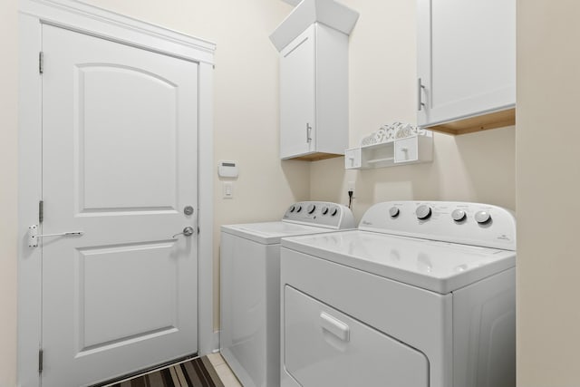 washroom with cabinets and washer and clothes dryer