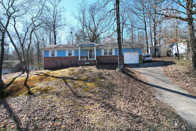 ranch-style home with a garage, aphalt driveway, crawl space, and brick siding