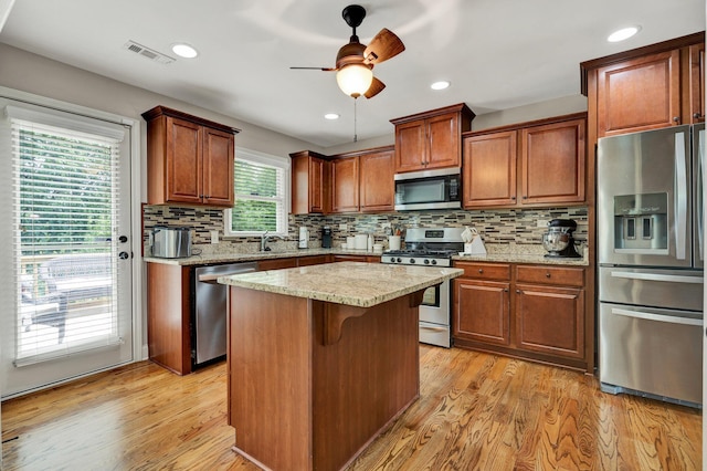 1851 Preservation Dr NE, Cleveland, TN 37323 - kitchen featuring stainless steel appliances, a sink, a ceiling fan, tasteful backsplash, and light wood-style floors