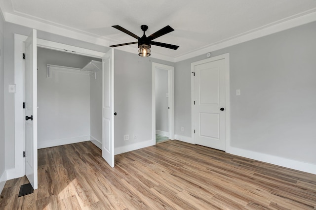 unfurnished bedroom featuring a closet, light wood-style floors, ceiling fan, baseboards, and visible vents