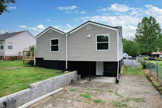 back of house featuring fence and a yard