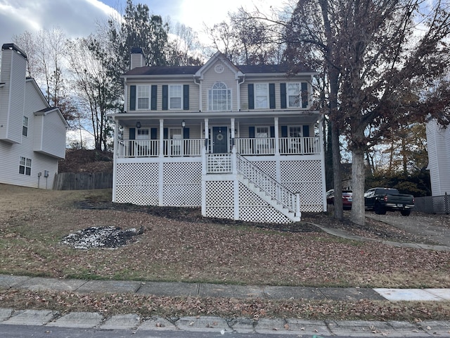 3722 Lockerbie Ln, Powder Springs, GA 30127 - colonial home featuring a porch, a chimney, fence, and stairway