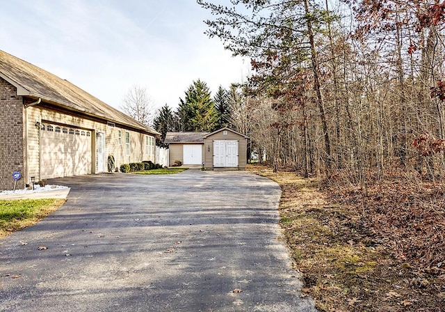 view of property exterior featuring a storage shed and a garage